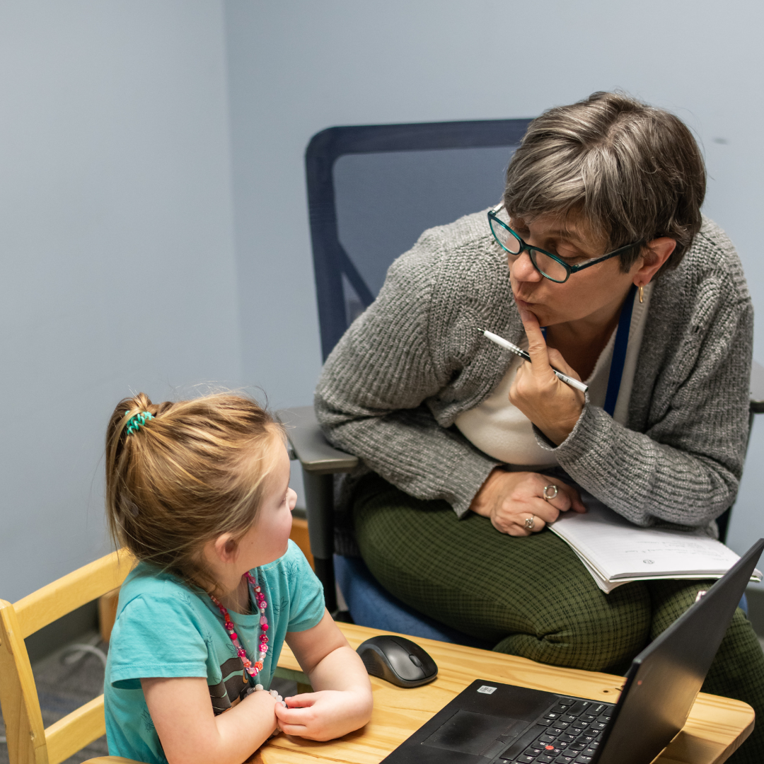 Therapist and child performing speech exercise.
